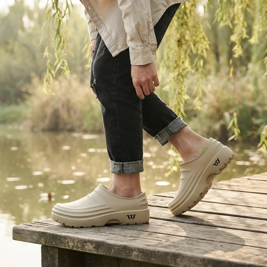 Outdoor lifestyle shot of beige platform clogs worn with rolled jeans while standing on a wooden dock