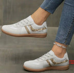 Beige suede trainers with tan leather stripes and white sole stitching, close side view