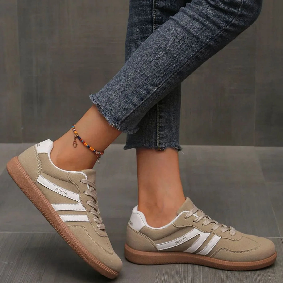 Close crop of beige trainer heel tab with WALKING text and suede texture detail