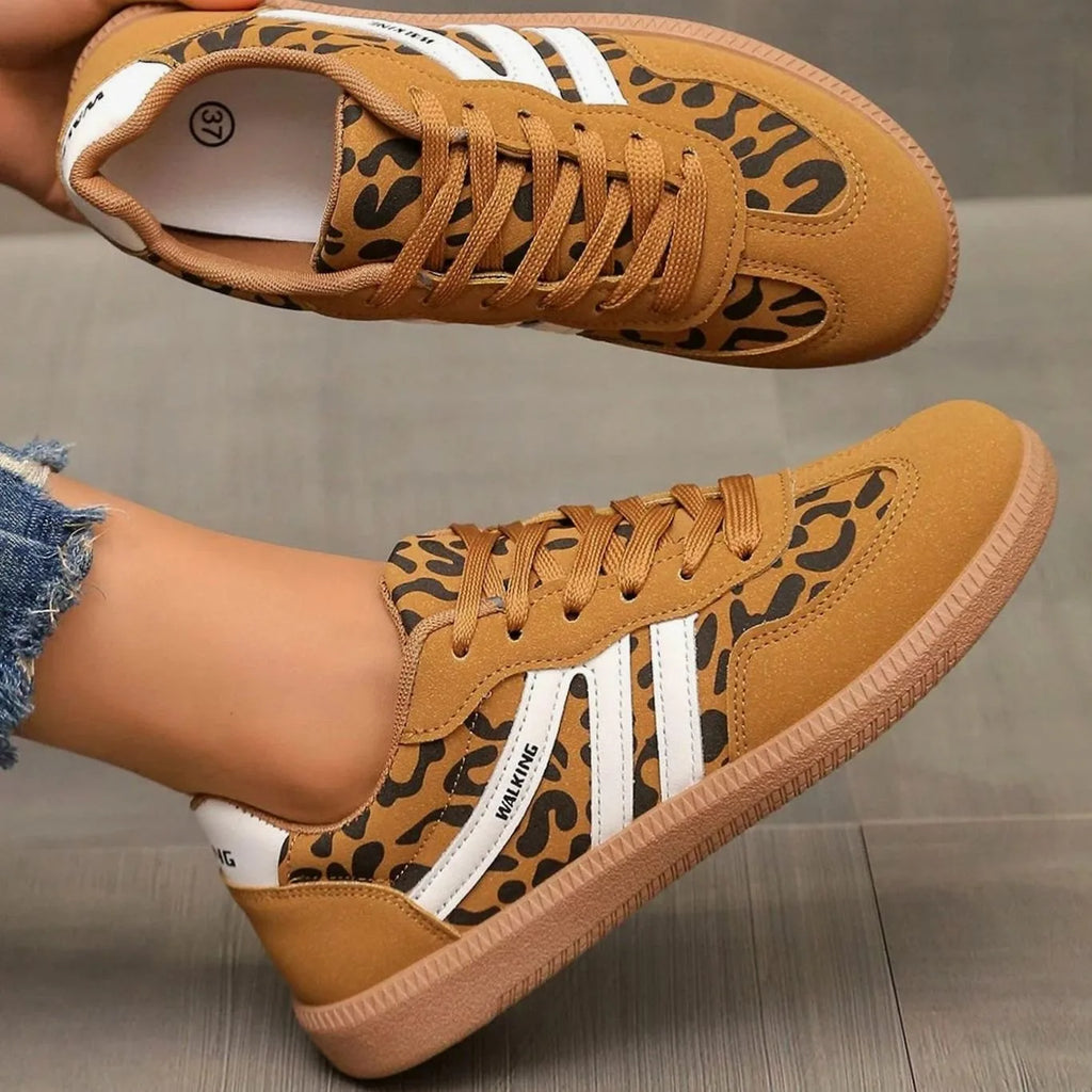 Close-up of stitched stripe panels on beige and taupe trainers with suede toe overlay