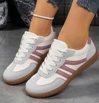 Beige trainers photographed from behind, showing heel curve and rubber sole ridges