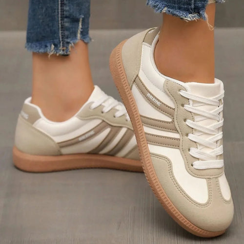 Close-up of beige suede and leather trainers with WALKING text on tongue and heel tab