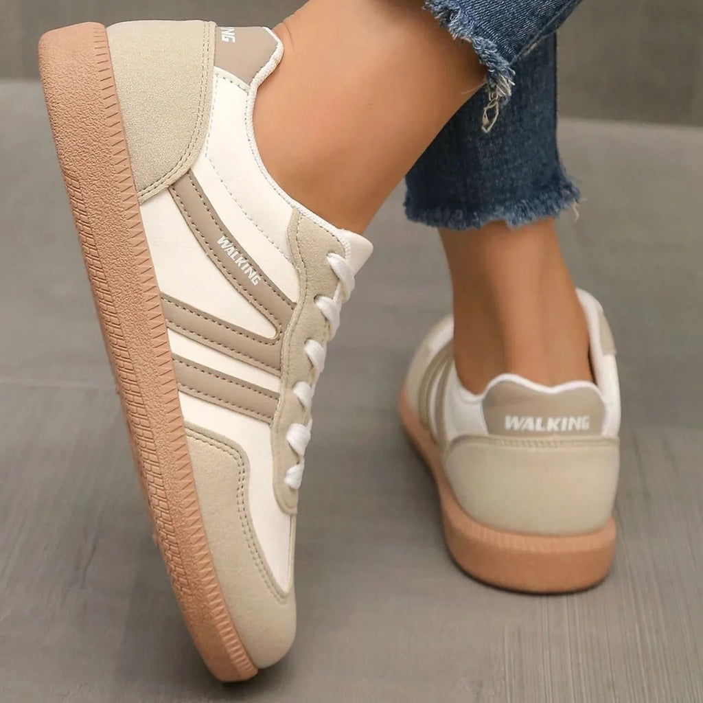 Back angle of beige trainers showing padded heel collar and ridged gum outsole texture