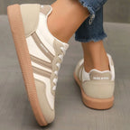 Back angle of beige trainers showing padded heel collar and ridged gum outsole texture