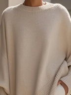 Close-up of the beige jumper's crew neckline and ribbed collar showing the fine knit texture