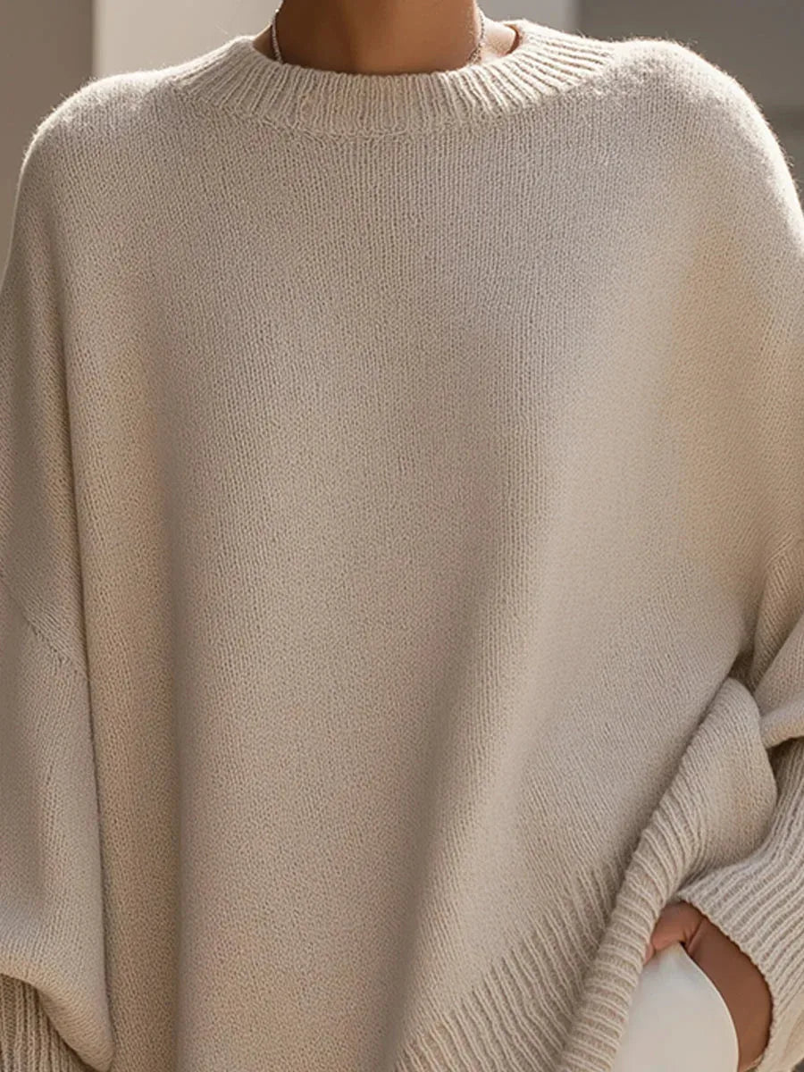 Close-up of the beige jumper's crew neckline and ribbed collar showing the fine knit texture