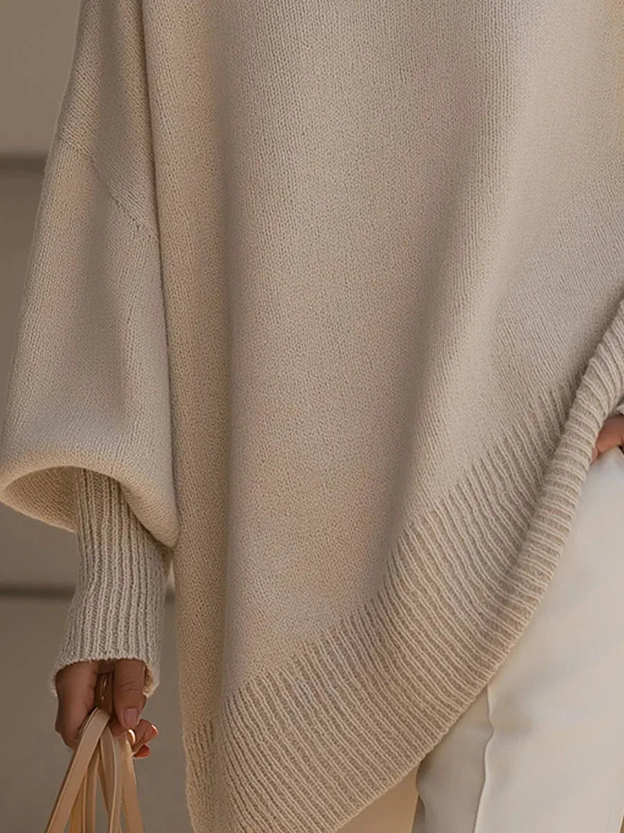 Detail of the asymmetric ribbed hem and batwing sleeve cuff on the beige oversized jumper