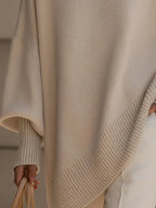 Detail of the asymmetric ribbed hem and batwing sleeve cuff on the beige oversized jumper