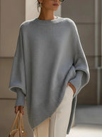 Woman wearing the oversized jumper in grey with wide batwing sleeves and ribbed hem