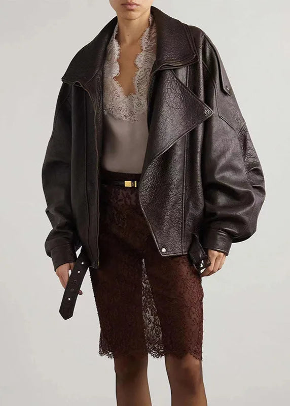 Front view of the brown leather bomber jacket open over a lace camisole, showing the belted waist detail