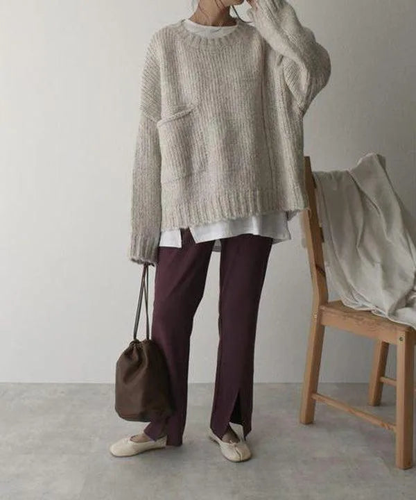 Side-front view showing the jumper's drop shoulder, patch pocket and ribbed cuffs paired with burgundy trousers