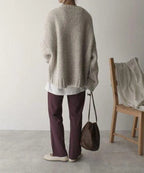 Back view of the beige knit jumper highlighting its relaxed oversized silhouette and ribbed hem