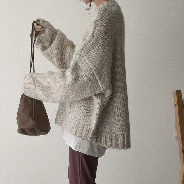 Close side profile showing the chunky knit texture, wide ribbed sleeve and soft drape of the jumper