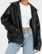 Close-up front view of the black leather jacket showing the zip fastening and wide collar detail