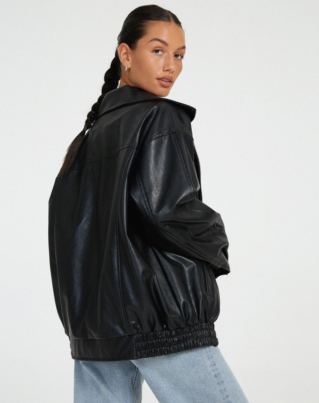 Side back view of the black oversized jacket highlighting the elasticated hem and collar shape