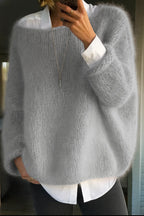 Side view of the chunky knit jumper in soft grey, worn over a crisp white collared shirt and dark trousers