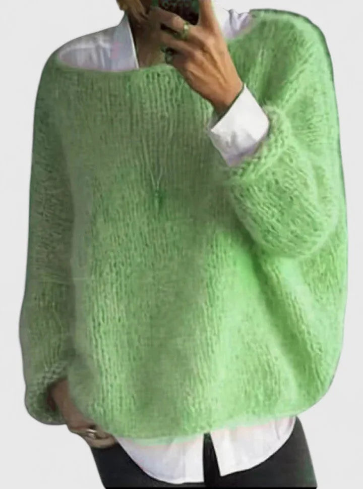 Light green fuzzy knit jumper with loose, oversized fit shown layered over a white shirt and dark trousers