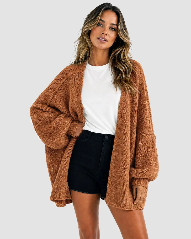 Front view of the cardigan in rust brown, styled open with a white tee and denim shorts