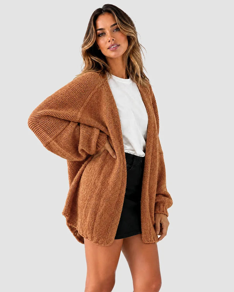 Side view of the rust brown cardigan showing the oversized silhouette and ribbed cuff detail