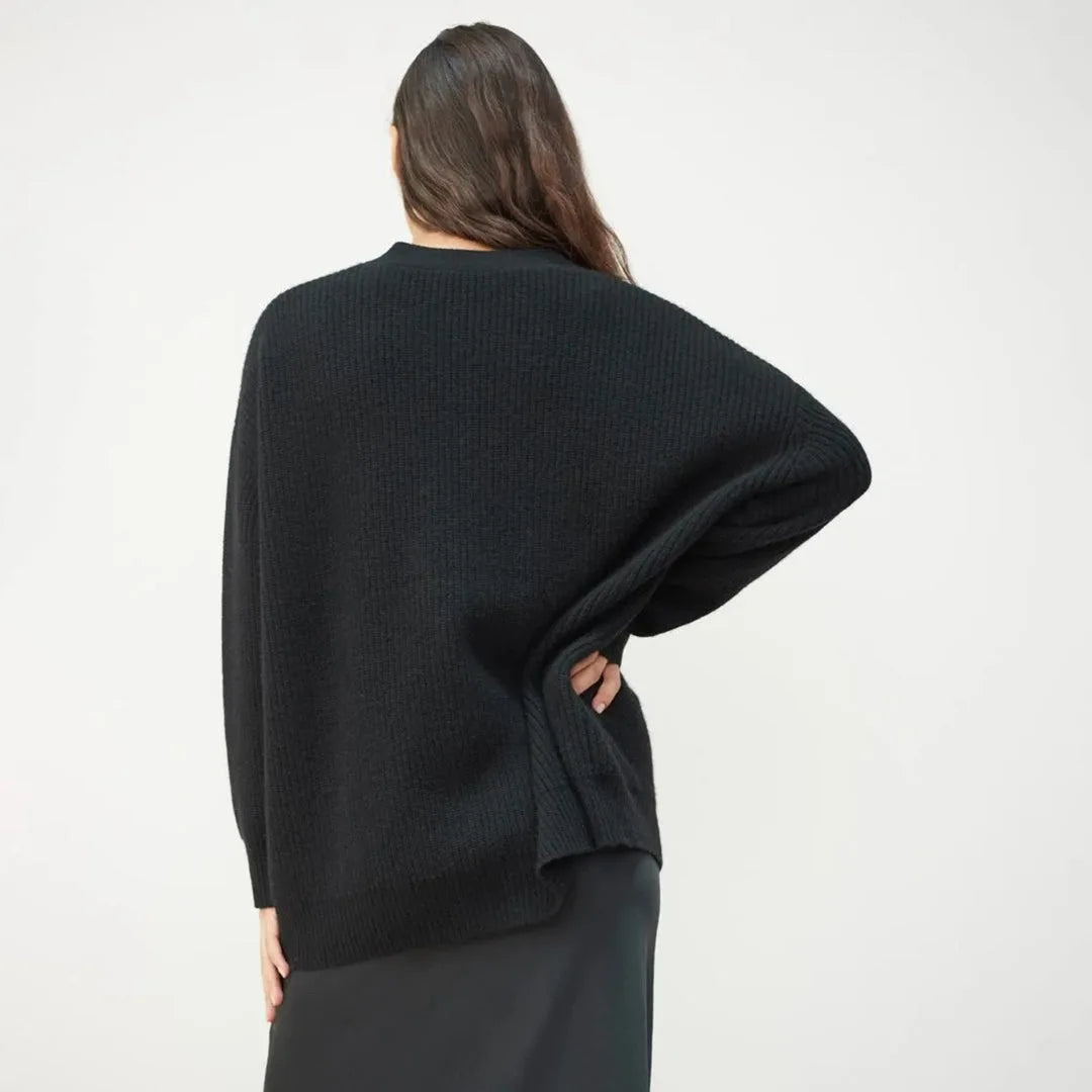 Back view of a black ribbed cardigan showing the relaxed oversized silhouette and dropped shoulders