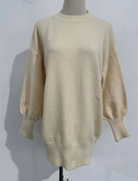 Front view of an oversized beige knit jumper with ribbed crew neckline and balloon sleeves on a mannequin