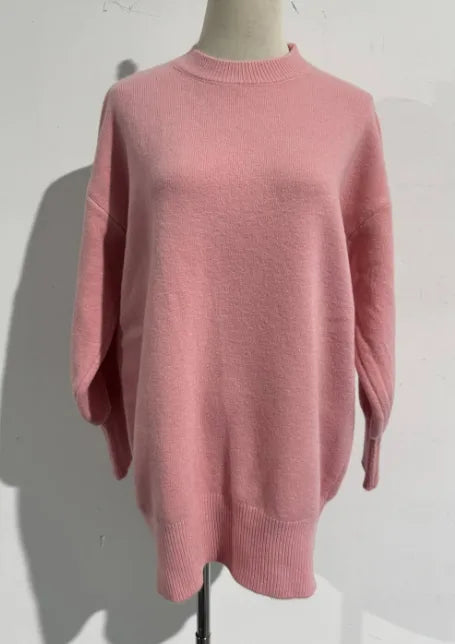 Pink oversized knit jumper on a mannequin, front view showing dropped shoulders and ribbed hem