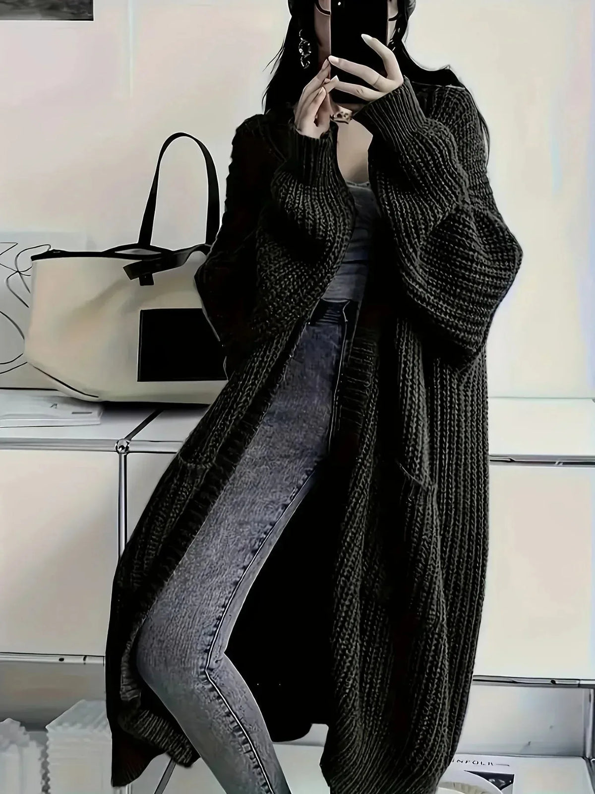 Long black ribbed knit cardigan shown open, oversized fit with wide sleeves and patch pockets