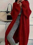 Deep red oversized cardigan in chunky rib knit, worn open over a grey top and jeans