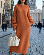 Woman in Prague old town wearing an oversized burnt orange ribbed knit maxi jumper dress with balloon sleeves