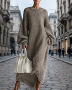 Grey oversized chunky knit maxi dress with balloon sleeves shown against a stone European street backdrop