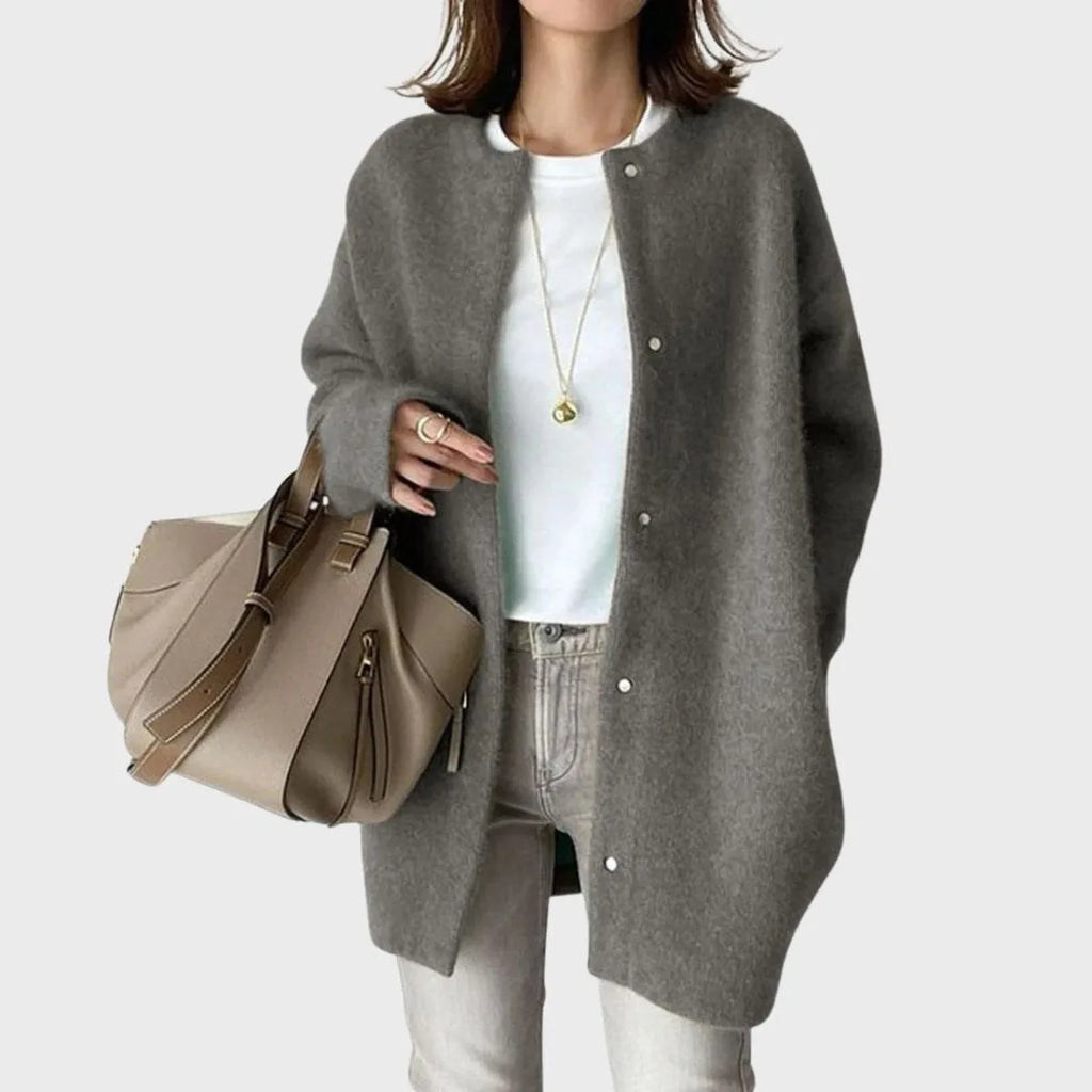 Grey knit cardigan with relaxed oversized fit shown open over a white top and jeans