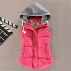 Fuchsia pink padded gilet with grey jersey hood, front snap buttons and side pockets, laid flat