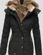Black quilted winter coat with fluffy faux fur hood lining and zippered side pockets, close-up front view