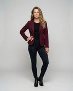 Model wearing a burgundy peplum blazer over a black top with dark jeans and ankle boots, full length front view