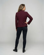 Back view of a model wearing a burgundy peplum blazer, showing the fitted waist seam and hem shape