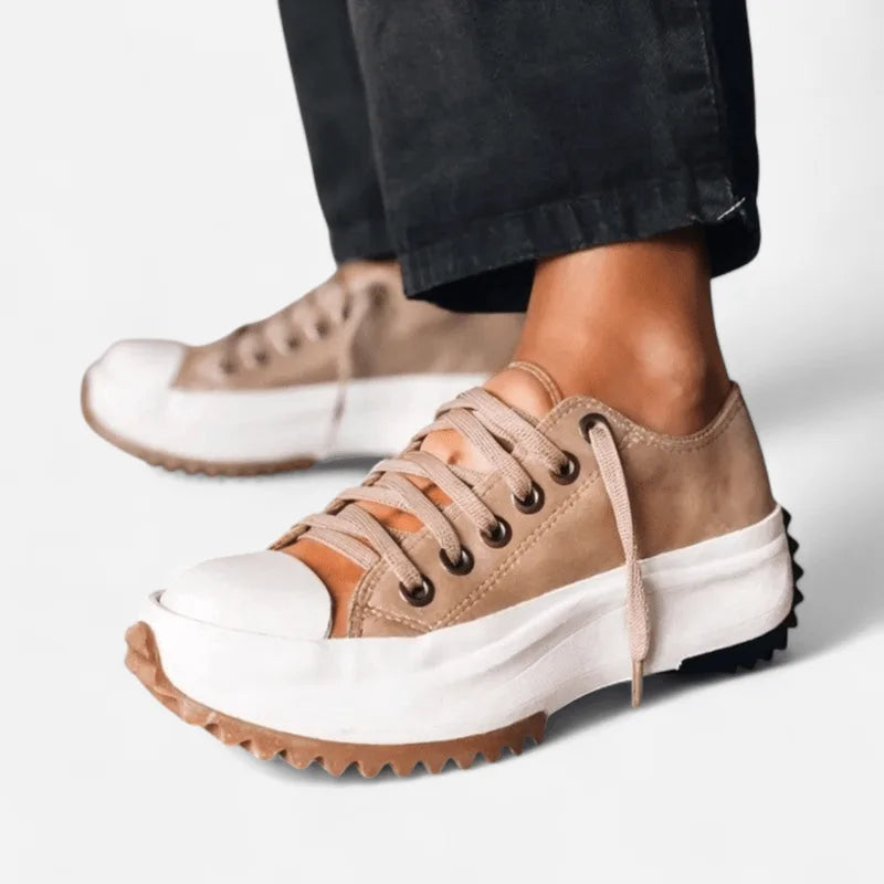 Angled view of tan suede lace-up platform trainers highlighting the cream midsole and deep tread pattern