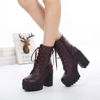 Side view of model wearing deep plum lace-up ankle boots with buckle detail and ridged platform sole