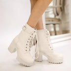 Model standing in cream white lace-up platform ankle boots with buckle strap, viewed from the side