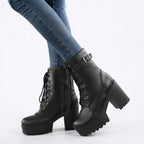 Model wearing black faux leather lace-up platform ankle boots with buckle strap, paired with skinny jeans