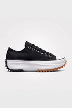 Side view of midnight black canvas platform trainer with black laces, white cap toe and gum-tipped serrated sole