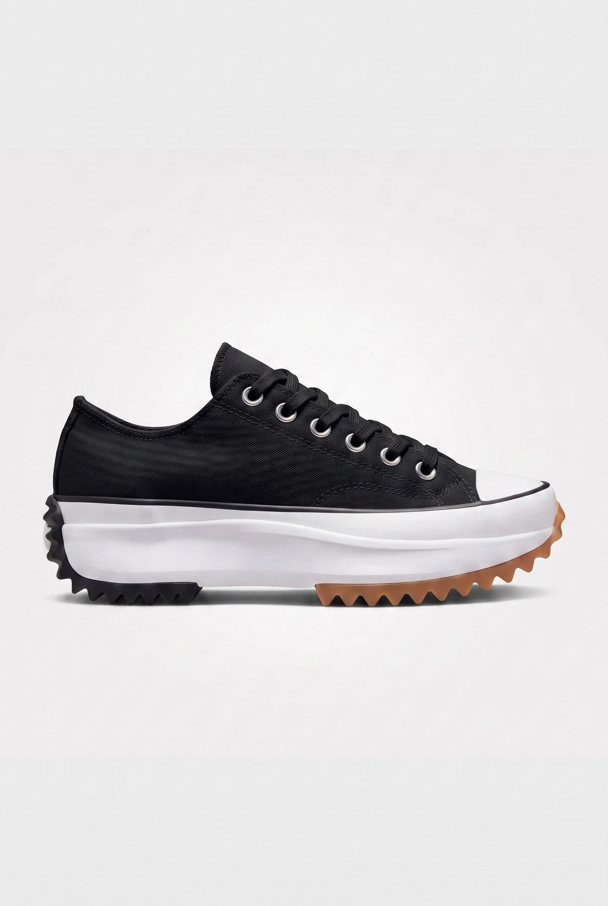 Side view of midnight black canvas platform trainer with black laces, white cap toe and gum-tipped serrated sole