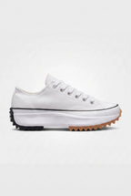 Side view of ivory white canvas platform trainer with white laces and black and gum serrated platform sole