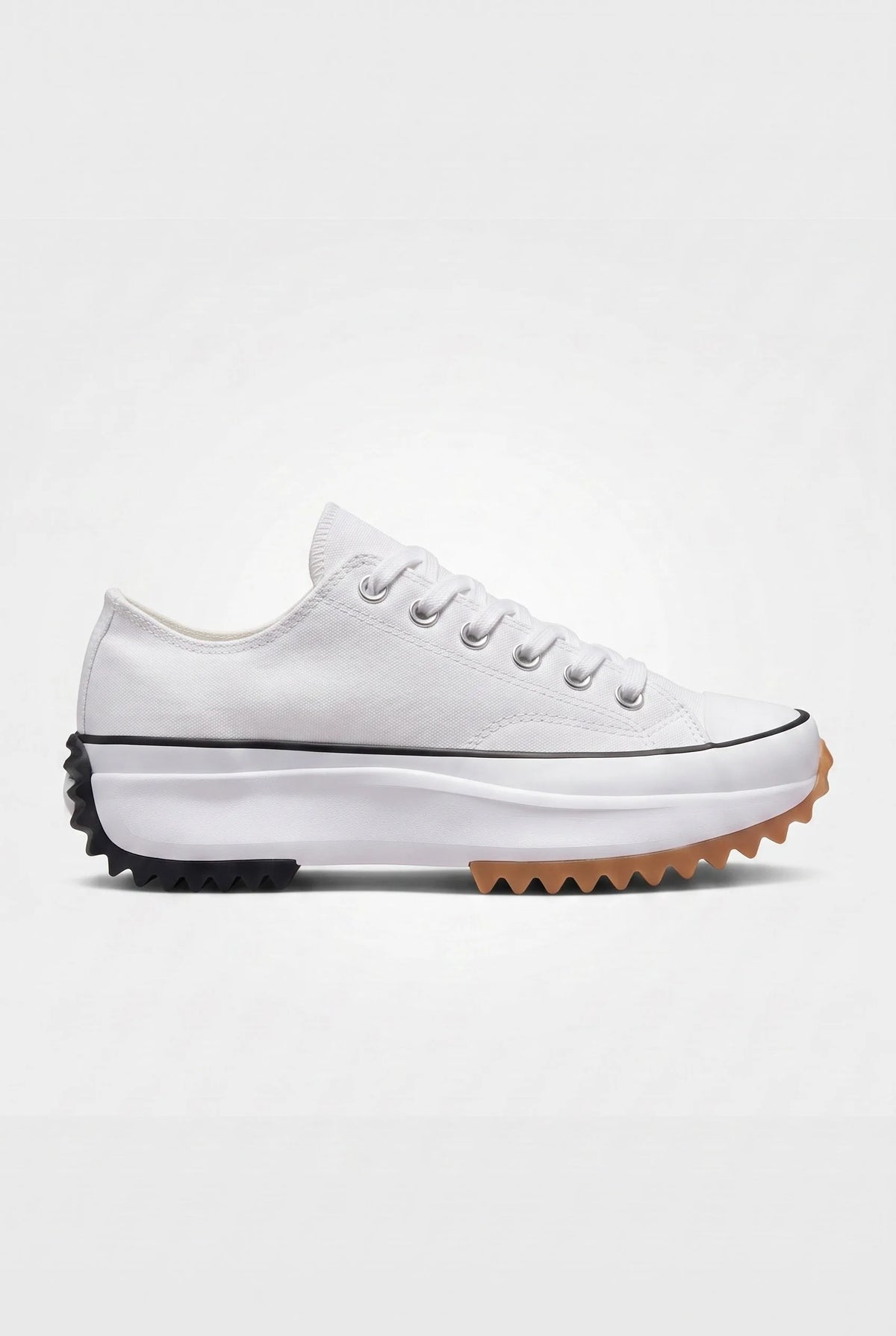 Side view of ivory white canvas platform trainer with white laces and black and gum serrated platform sole