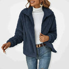 Navy blue plush zip cardigan with wide lapel collar layered over a white polo neck top