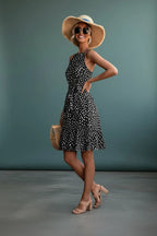 Three-quarter view of the polka dot mini dress showing the halter straps and A-line skirt silhouette