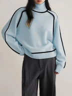 Model wearing cream polo neck jumper paired with dark grey wide-leg trousers