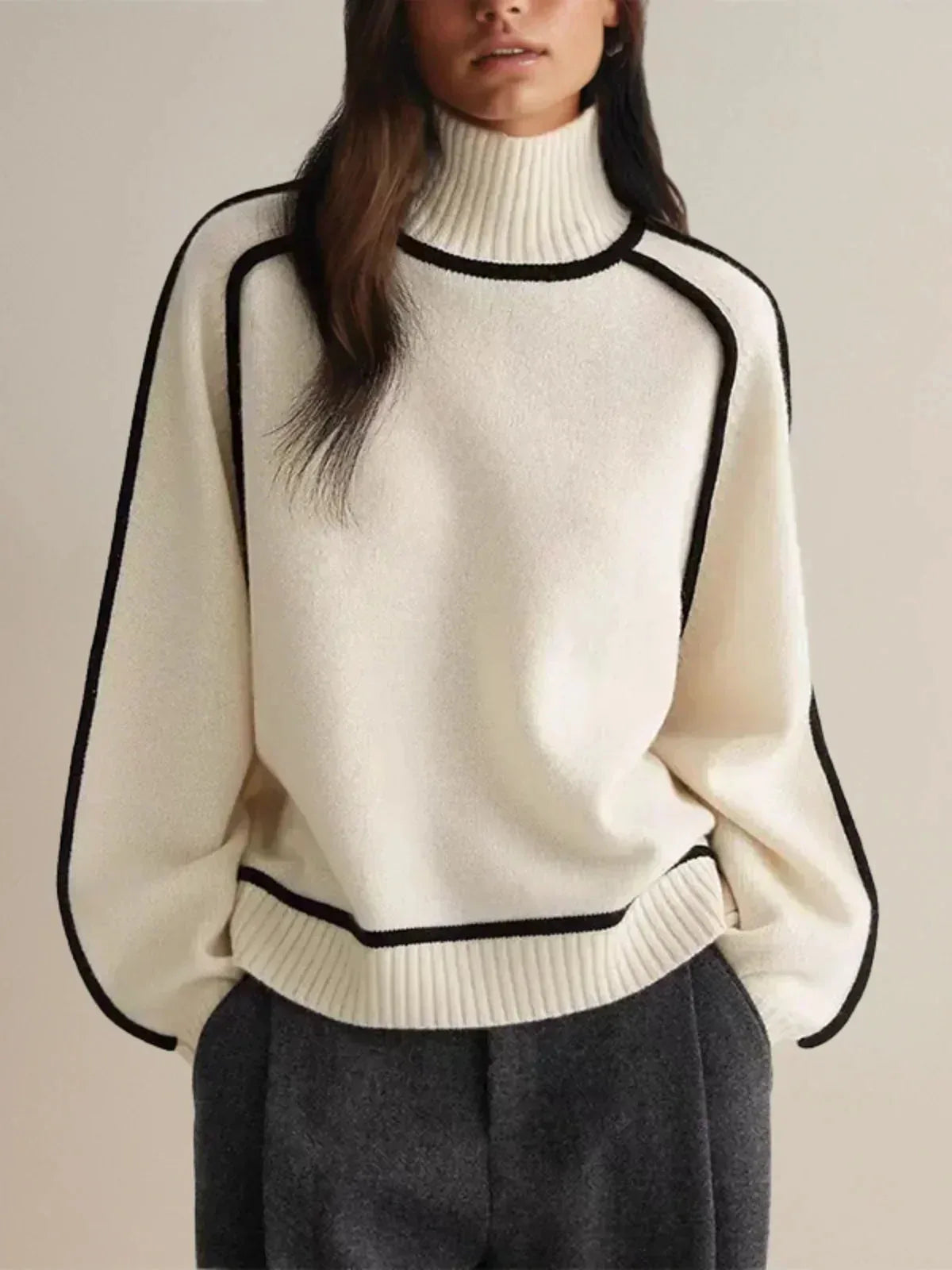 Front view of cream ribbed turtleneck jumper showing black piped seams and dropped shoulder cut