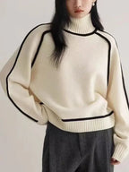 Detail shot of ivory knit jumper highlighting the ribbed hem and black trim outline on the chest