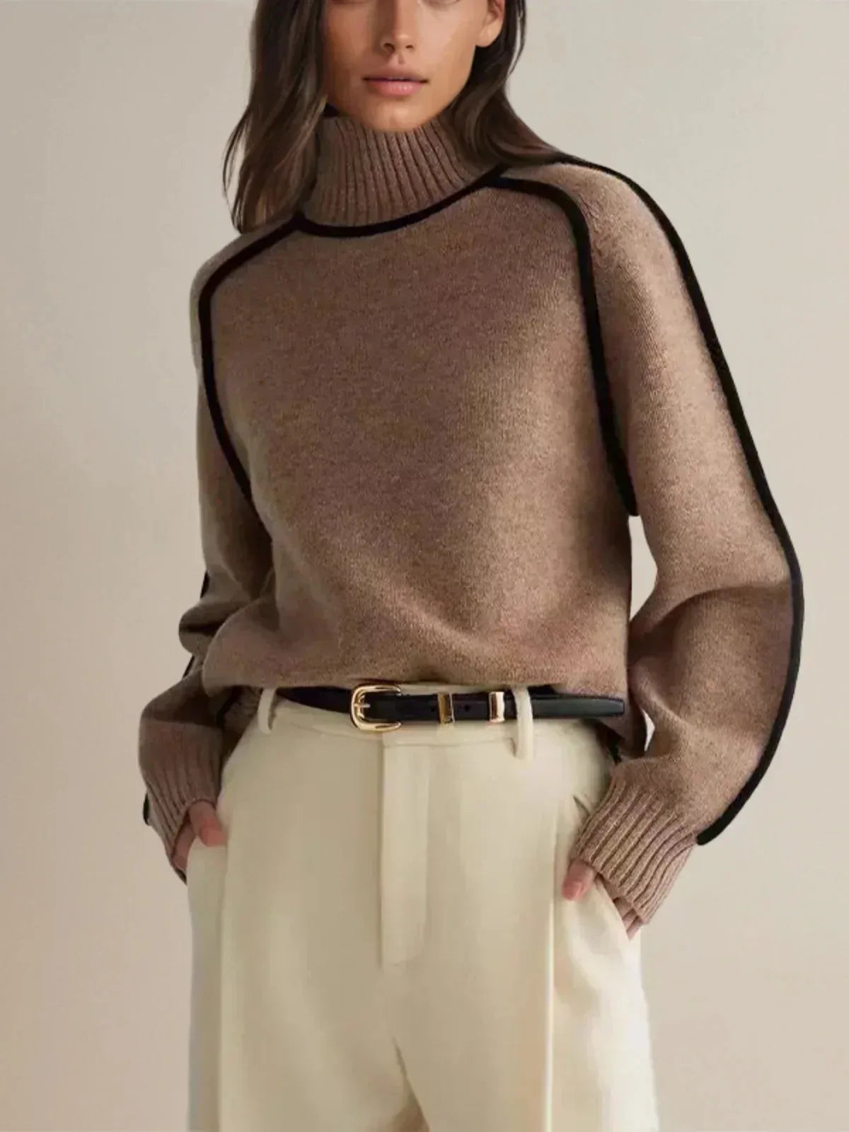 Cropped view of oatmeal polo neck jumper with visible ribbed cuffs and contrast piping down the arm