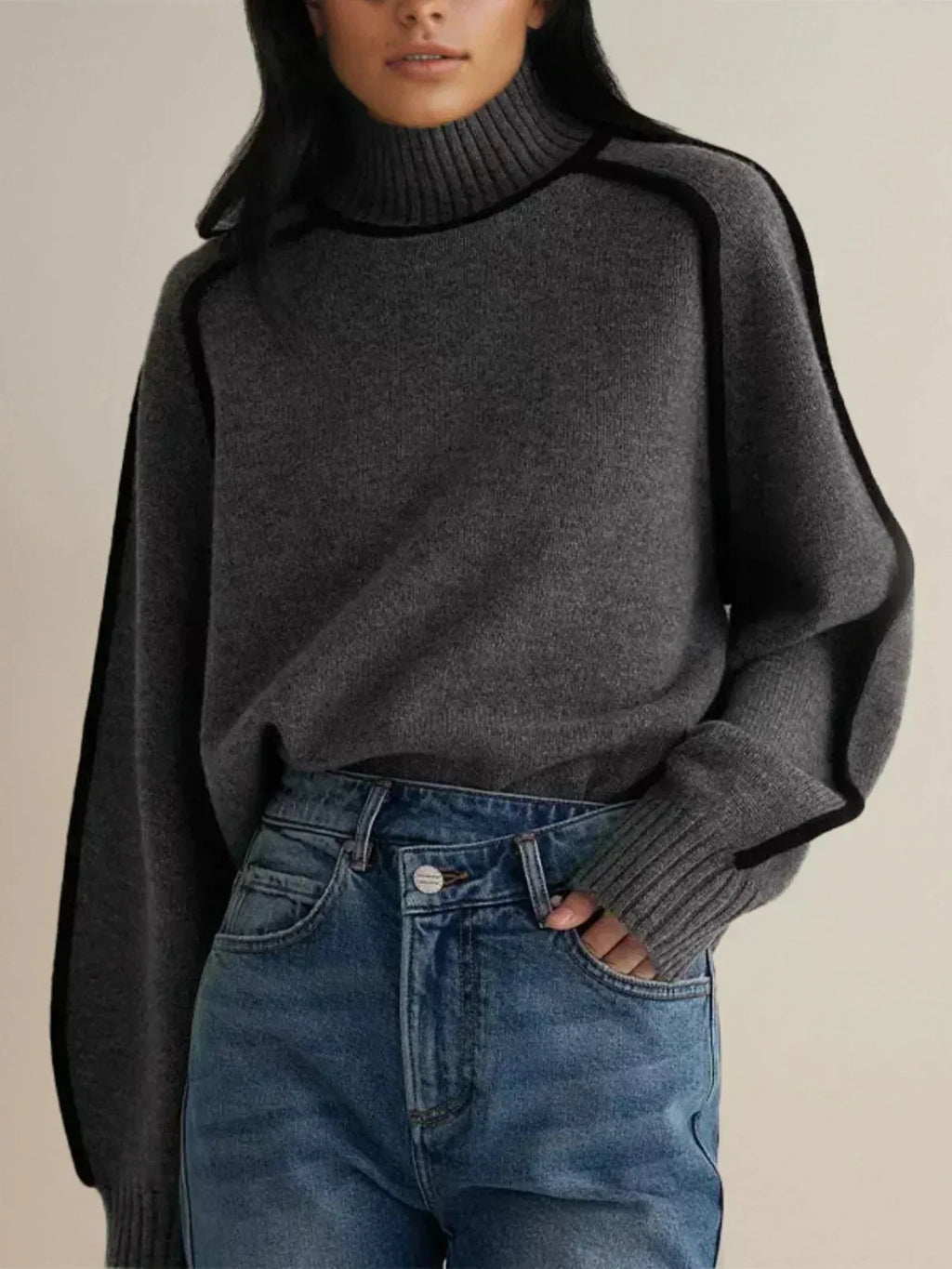 Close view of brown polo neck jumper with ribbed collar and piped raglan seam over the shoulder